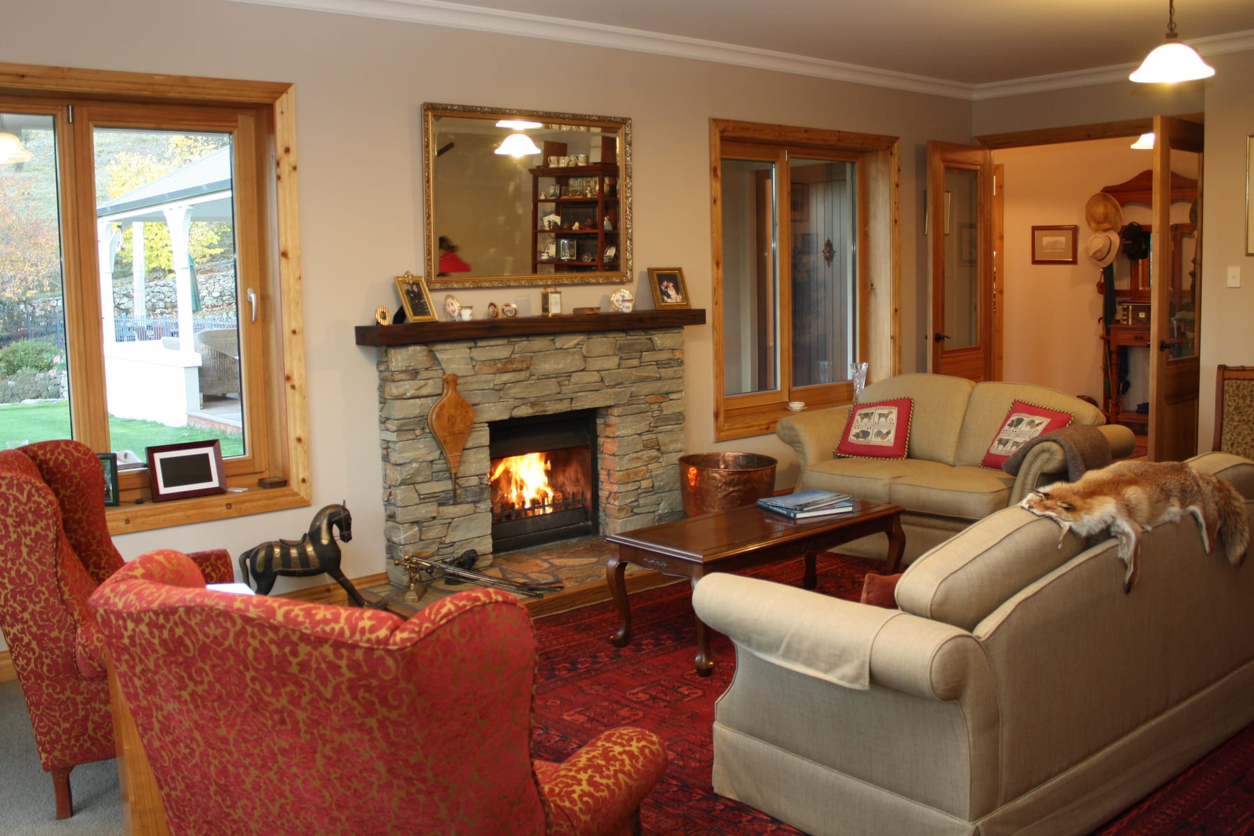 Homestead sitting room with a fire burning in the schist fireplace