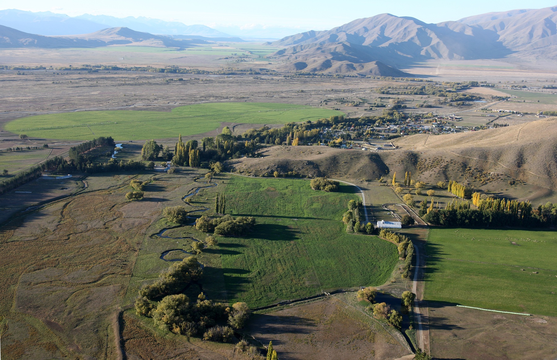 Aerial view over Omarama Station's paddocks and braided streams to the Mackenzie Country ranges