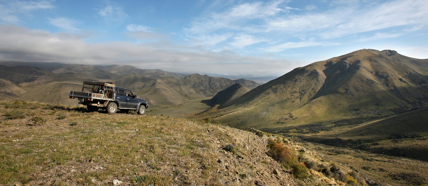A station truck on a ridge above sweeping High Country valleys near Omarama
