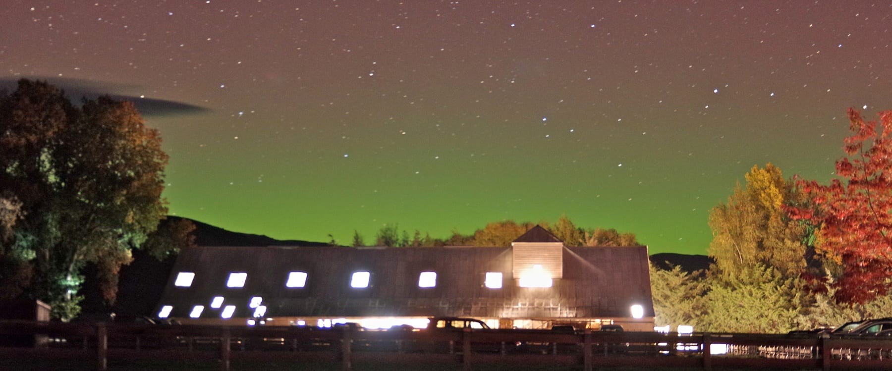 The aurora australis glowing green above the woolshed at night