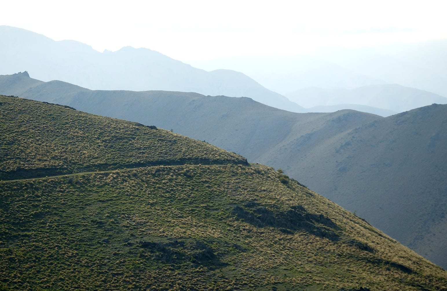Layered high country ridges above the station, receding into the haze