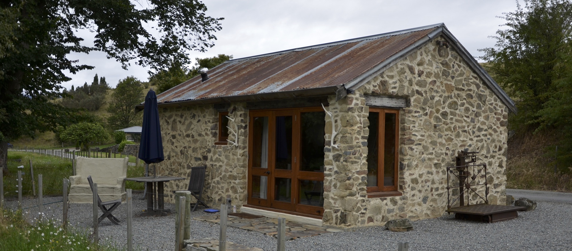 Stone hut set in a tussock valley at the foot of the hills